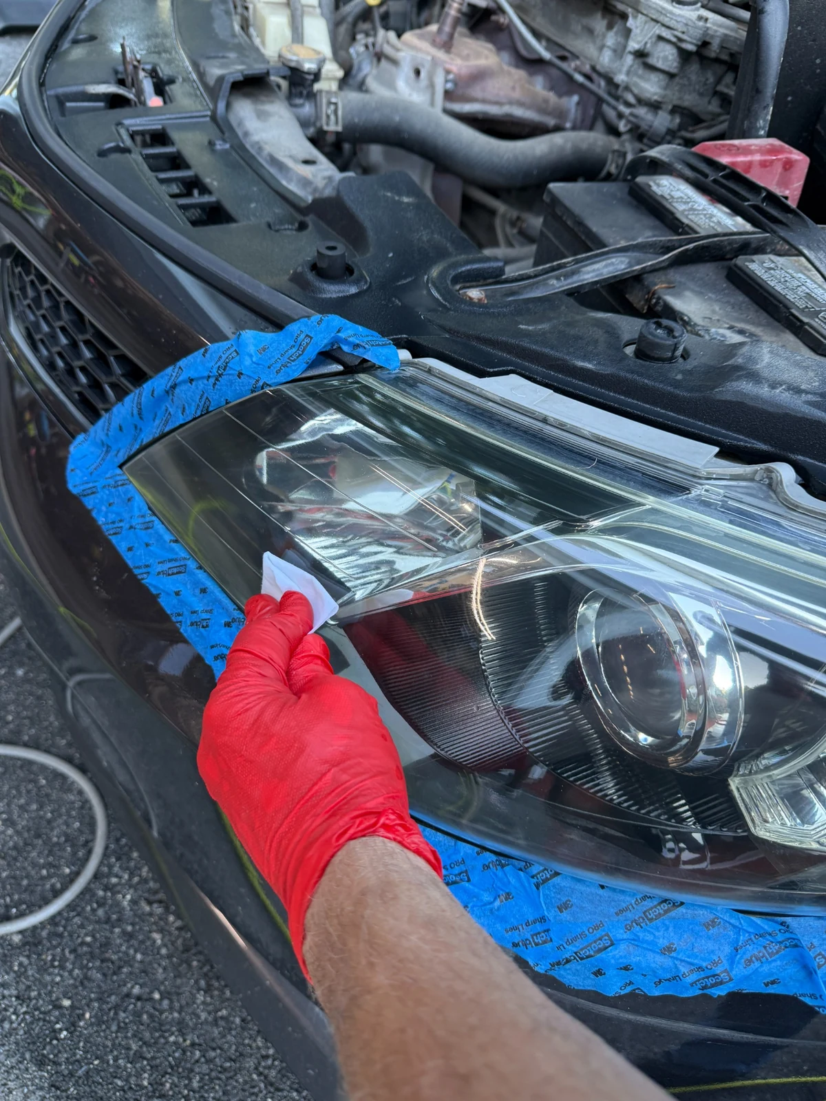 Technician restoring oxidized Honda Accord headlight in Stoneham MA using polishing process