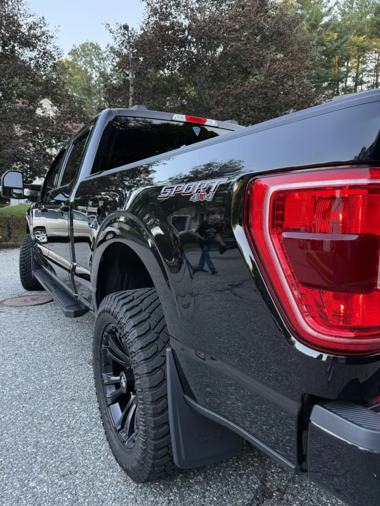 Black Ford F-150 after ceramic coating showing mirror-like reflections